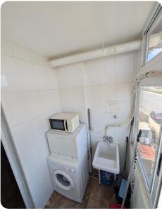 a small bathroom with a microwave on top of a toilet at Casa Lyngra in Orihuela Costa