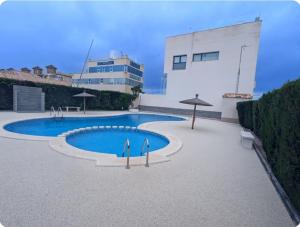 a swimming pool in front of a building at Casa Lyngra in Orihuela Costa