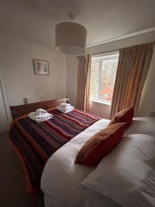 a bedroom with a bed with two towels on it at The Forge in Avington