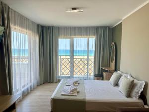 a bedroom with a bed with a view of the ocean at Teos Apartments Primorsko in Primorsko