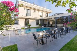 a patio with tables and chairs next to a swimming pool at Rossa Marin Hotel in Darıca