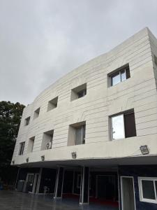 a large white building with many windows at Sakkhar Palace in Indore