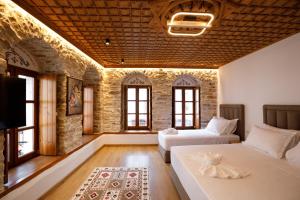 a large room with two beds and a couch at Hotel Kashah in Gjirokastër