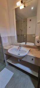 a bathroom with a sink and a large mirror at Park Hotel in Hévíz