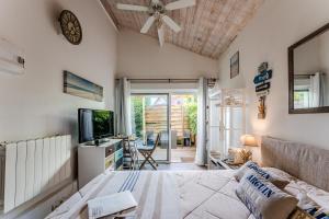 a room with a bed and a tv and a couch at Villa Saint Barth in Gujan-Mestras