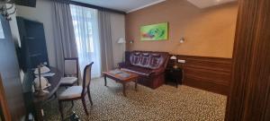 a living room with a leather couch and a table at Park Hotel in Hévíz +39 photos
