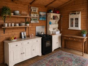 a kitchen with white cabinets and a stove at Oceanview Cosy Cabin in Drumaville