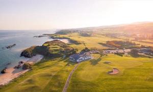 an aerial view of a golf course next to the ocean at Oceanview Cosy Cabin in Drumaville