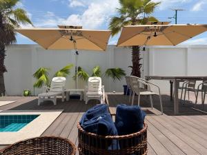 a deck with chairs and a table and umbrella at LaViena pool villa in Vientiane