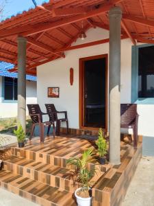 a patio with two chairs and a wooden deck at Misty field view Homestay in Ponnampet