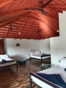 a room with three beds and a ceiling fan at Misty field view Homestay in Ponnampet