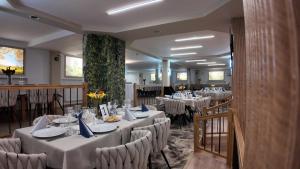 a dining room with white tables and chairs at Hotel Darina Select in Târgu-Mureş