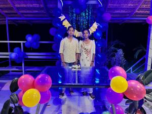 two people standing next to a table with balloons at Misty field view Homestay in Ponnampet