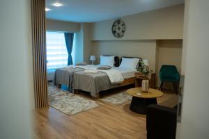 a bedroom with a bed and a clock on the wall at Hotel Darina Select in Târgu-Mureş