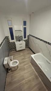 a bathroom with a toilet and a sink and a tub at Victor Hugo's Le Central in Saint-Junien