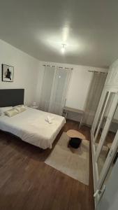 a bedroom with a white bed and a wooden floor at Victor Hugo's Le Central in Saint-Junien +2 photos
