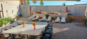 a patio with a table and chairs and umbrellas at Cal Belló in Hostafranco