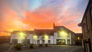 a building with a sunset in the sky behind it at Lomond Hills Hotel & Health Club in Freuchie