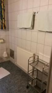 a tiled bathroom with a chair and a towel at Apart Beate in Kappl