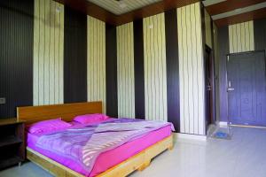 a bedroom with a bed with pink sheets and a door at Hotel Ekant Valley in Chakrāta