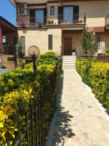 ein Zaun vor einem Haus mit Blumen in der Unterkunft Da Fernanda in Guidonia + 3 Fotos