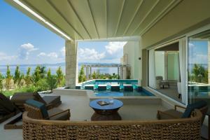 a house with a pool and a patio with chairs and a table at Kappa Resort in Paliouri