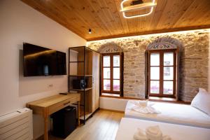a bedroom with a bed and a tv in a building at Hotel Kashah in Gjirokastër
