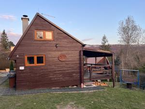 a large wooden house with a porch at Chata Victory in Rajnochovice