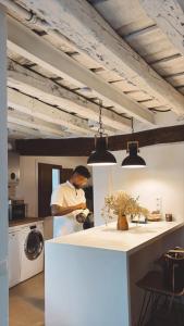 a man in a kitchen with a washing machine at Casa Chía in Arenas de San Pedro