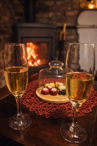 two glasses of wine on a table with a plate of food at Breg&Spa in Beretinec