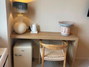 a desk with a vase and a lamp and a chair at Calabianca in Giglio Porto