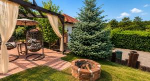 a patio with an umbrella and a fire pit at Breg&Spa in Beretinec