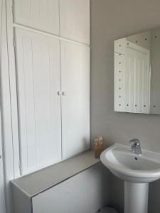 a white bathroom with a sink and a mirror at Jagger Green Retreat in Greetland +9 photos