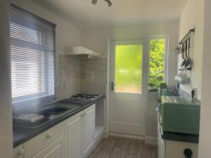 a kitchen with a sink and a stove top oven at Jagger Green Retreat in Greetland