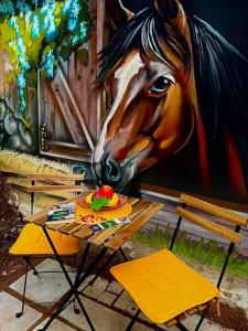 a table with a plate of fruit in front of a horse painting at Вила Рози, Семково in Belitsa
