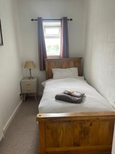 a bedroom with a wooden bed with a window at Jagger Green Retreat in Greetland