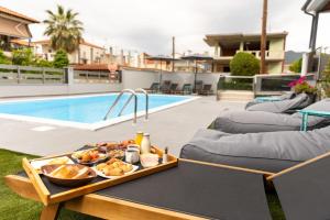a tray of food on a table next to a pool at Amalia Center in Nea Vrasna