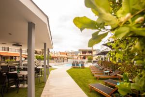 an outdoor patio with tables and chairs and a pool at Amalia Center in Nea Vrasna