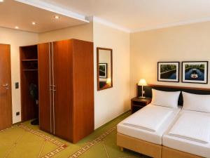 a bedroom with a bed and a cupboard and a bed at FlexInn Hotel Gelsenkirchen in Gelsenkirchen +18 photos