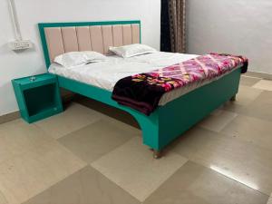 a bed in a room with a green frame at Hotel RV in Jhānsi