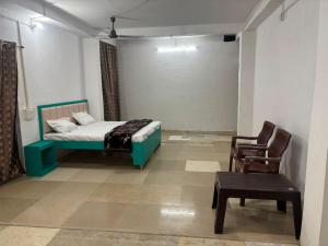 a bedroom with a bed and a chair at Hotel RV in Jhānsi