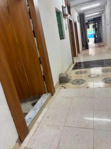 an empty hallway with a door and a tile floor at Hotel RV in Jhānsi