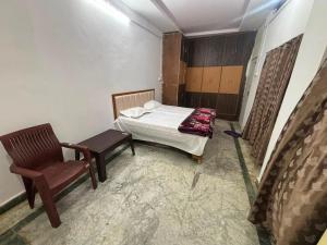a room with a bed and a chair in it at Hotel RV in Jhānsi