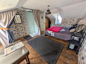a small bedroom with a bed and a table at La Passerelle in Loguivy-Plougras