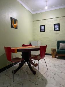 a room with a table with chairs and a couch at Kisubi Forest View in Entebbe +21 photos