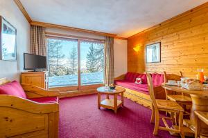 Zimmer mit einem Esstisch und einem Zimmer mit einem Fenster in der Unterkunft Lagrange Vacances Aspen in La Plagne