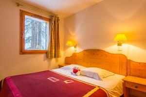 ein Schlafzimmer mit einem Bett, auf dem ein Teddybär liegt in der Unterkunft Lagrange Vacances Aspen in La Plagne + 30 Fotos