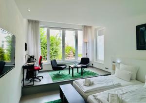 a white room with a bed and a desk and chairs at Feldberg4you DesignZimmer in Feldberg