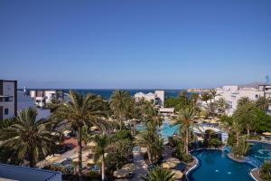 an aerial view of a resort with palm trees and a pool at Seaside Los Jameos in Puerto del Carmen