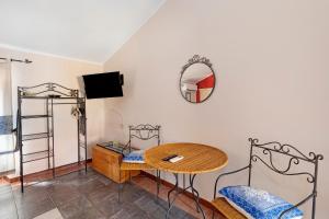 a living room with a table and a mirror at Romeo e Giulietta Rooms in Bosa